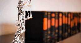 Statue holding a scale with legal books in the background