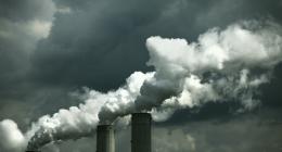 Power plant emitting air pollution, black & white