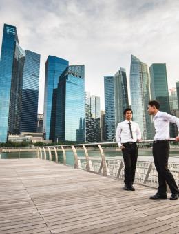 Deux collègues discutent sur un pont près de buildings. 