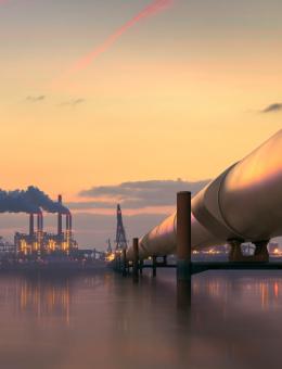 Large pipe going towards a power plant in the background