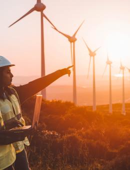 Workers on a wind farm at sunset
