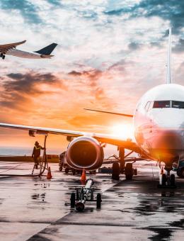 A grounded aeroplane with another in flight behind it