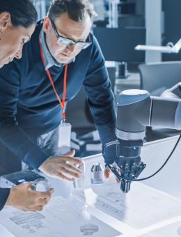 Two workers using a robotic device 