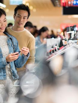 Woman and man shopping for cosmetics in a department store