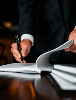 Person writing on a contract, only hands visible