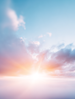 Sun peeking through clouds in a blue sky