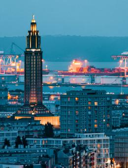Shipping port seen at night from a big city
